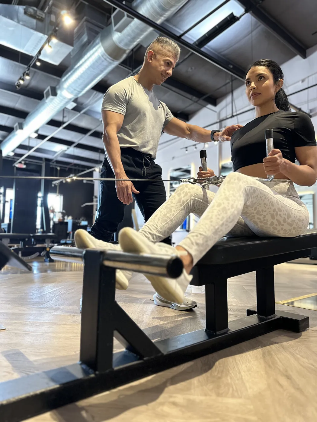 A ZERO coach guiding a client through a seated row in the private studio in Pearland