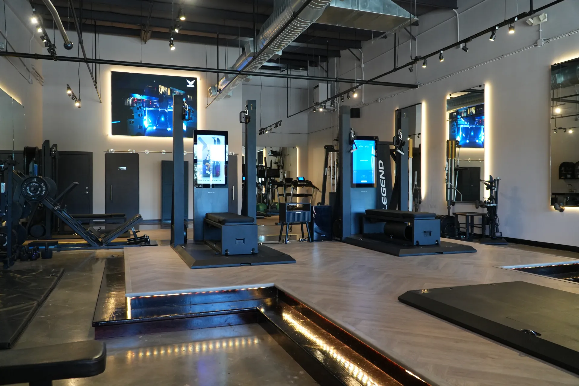 The main training floor at ZERO Training Center in Pearland, with lit platforms and screens